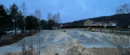 A construction site with a building and treesAI-generated content may be incorrect.