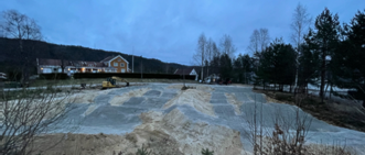 A construction site with a building and treesAI-generated content may be incorrect.