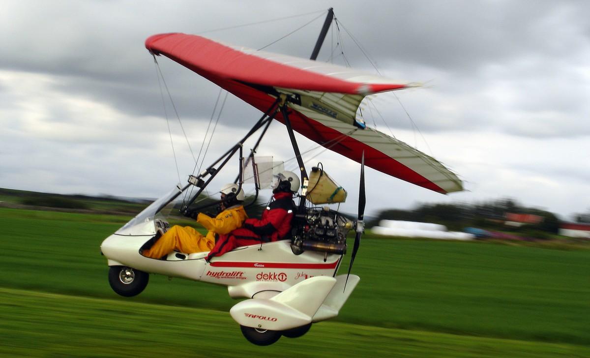 A person in a swing glider flyingDescription automatically generated