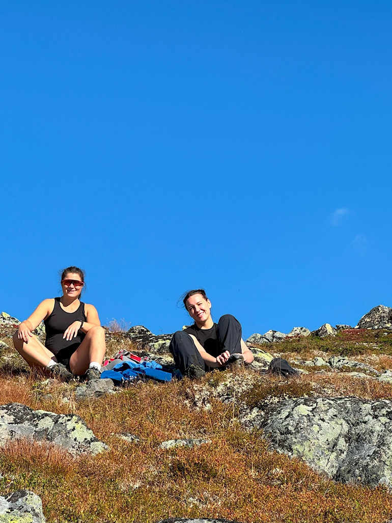 A person and person sitting on a rocky hill AI-generated content may be incorrect.