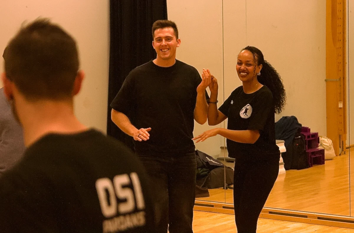 Smilende par danser bachata på salsa kurs for nybegynnere
