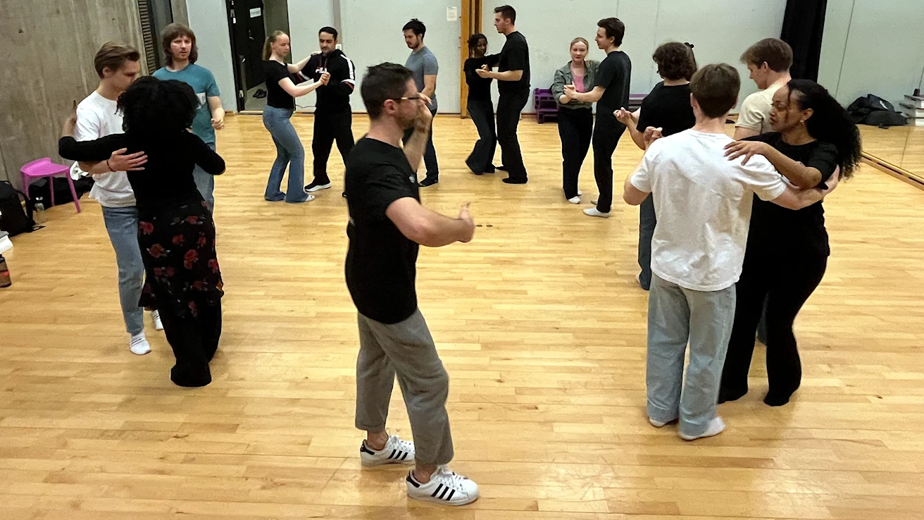 Dansepar på dansekurs i Oslo gjentar dansetrinn sammen med instruktører