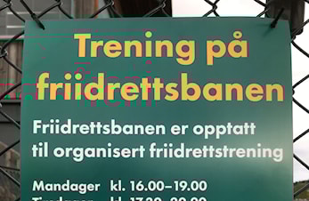 Info-plakater om hensyn og trening på Marienlyst friidrettsbane.