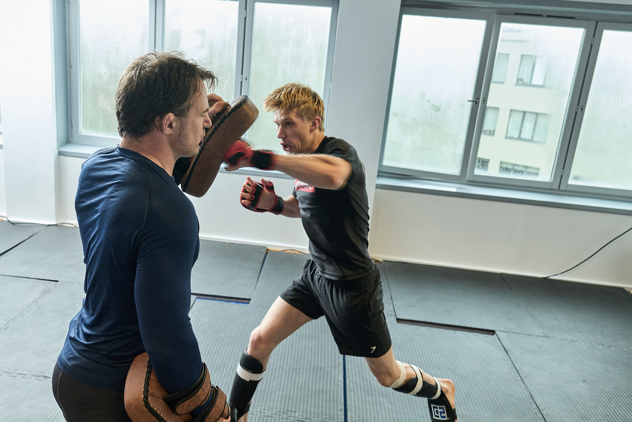 Bilde på en takedown av utøvere i MMA-oktagonen