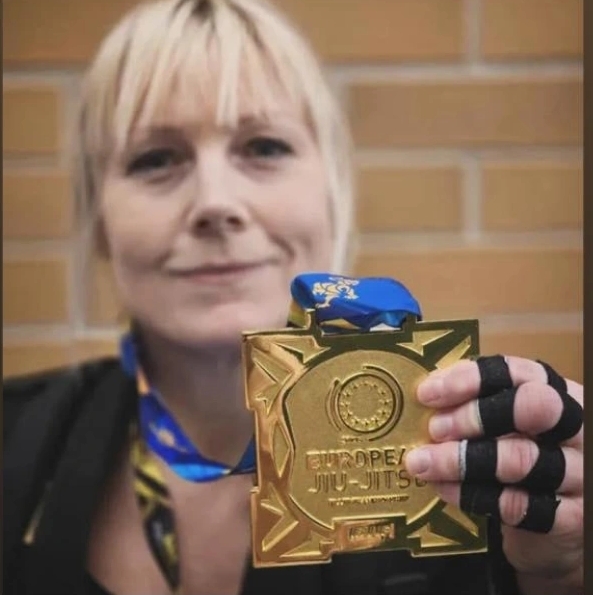 Bilde av EJJs instruktør Trine Jensen som holder i gullmedalje