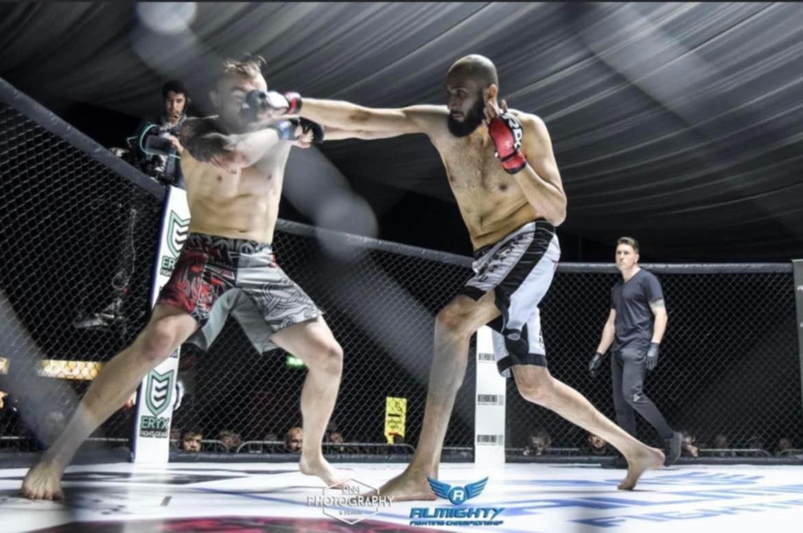 To utøvere fighter i ringen i Almighty Fighting Championship, der en utøver får et slag på haken